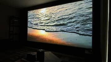 A large flat-screen TV displaying a sunset over the ocean.