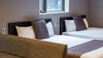 A hotel room with two beds, a window, and a view of the outside.