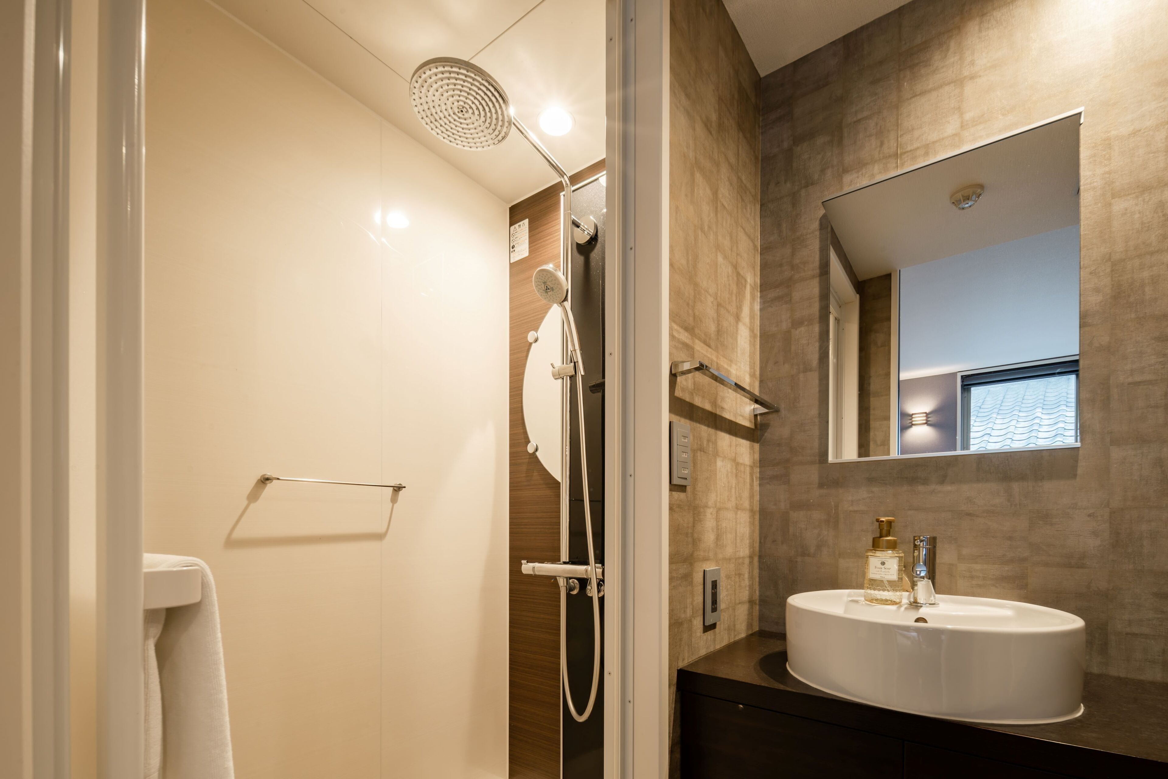 A modern bathroom with a shower, a sink, and a mirror.