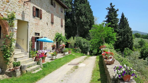 A stone building with a rustic exterior, a gravel path, and potted plants. - Cosy apartment in villa for 2 people with WIFI, pool, terrace, pets allowed and panoramic view (Pulicciano)