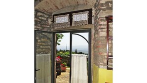 An open doorway leading to a balcony with a view of the countryside. - Cosy apartment in villa for 2 people with WIFI, pool, terrace, pets allowed and panoramic view (Pulicciano)