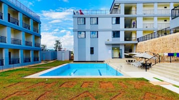 Kolam renang outdoor, dengan payung kolam renang dan kursi berjemur