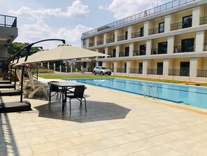 Piscine extérieure, parasols de plage, chaises longues