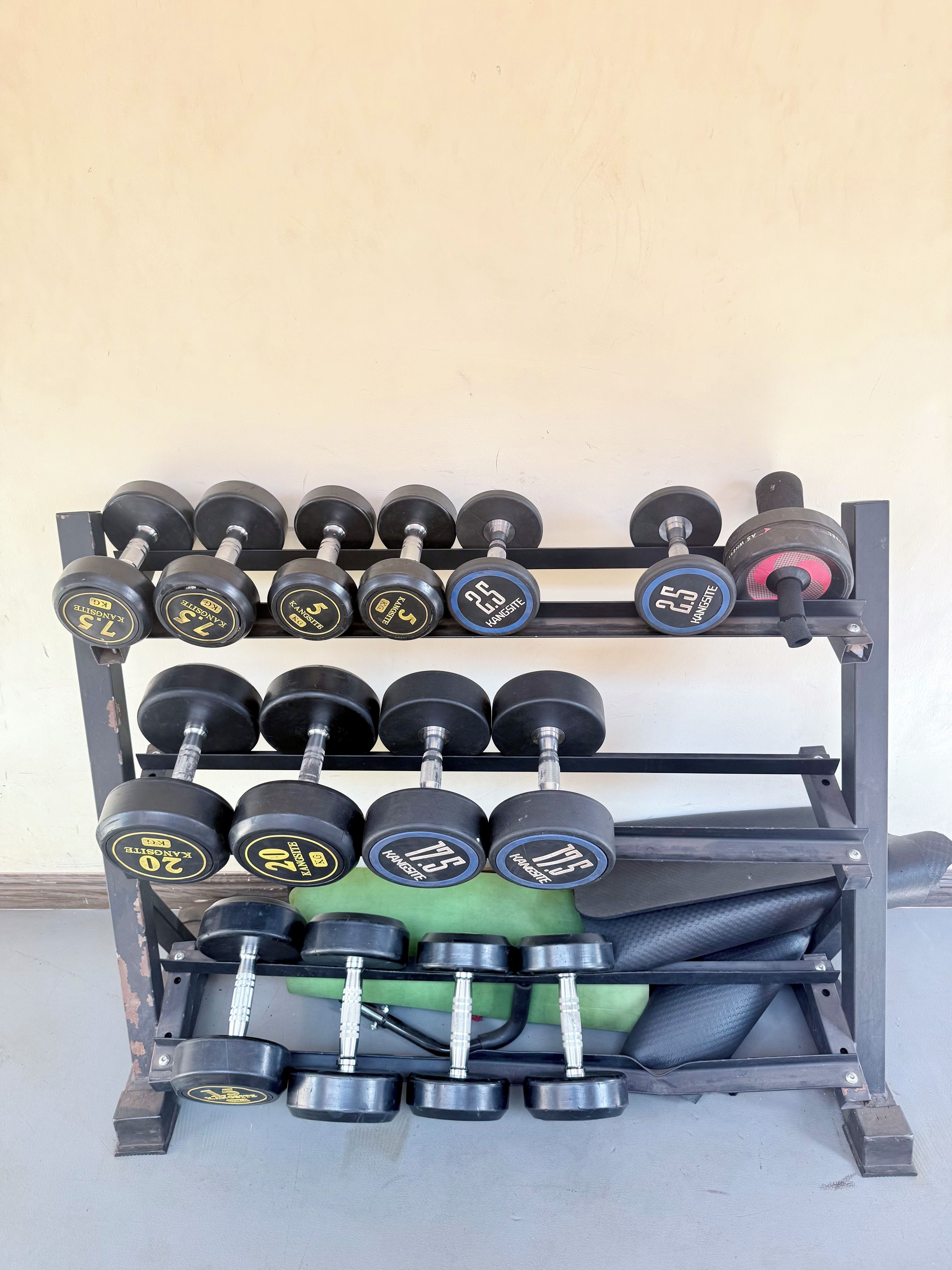 A weightlifting rack with multiple sets of dumbbells.