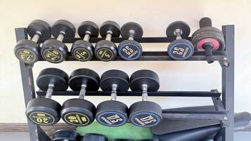 A weightlifting rack with multiple sets of dumbbells.