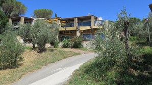 A two-story building with balconies, surrounded by olive trees and a clear sky. - Cosy apartment in villa for 11 people with pool, terrace and pets allowed (Guardistallo)