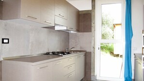 A modern kitchen with a gas stove, stainless steel appliances, and light-colored cabinetry. - Cosy apartment in villa for 11 people with pool, terrace and pets allowed (Guardistallo)