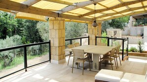 An outdoor patio with a table and chairs, a wicker sofa, and a glass-top coffee table. - Cosy apartment in villa for 11 people with pool, terrace and pets allowed (Guardistallo)