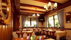 Un restaurante con interiores de madera, varias mesas y sillas.