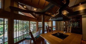 A spacious room with large windows, wooden beams, and a central table with a sink. - inn NOSHIYU (Minamioguni)
