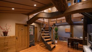 Un interno moderno con una scala in legno, una scrivania e una pianta in vaso.