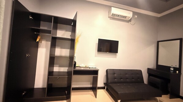 A modern bedroom with a wardrobe, a bed, a desk, and a TV.