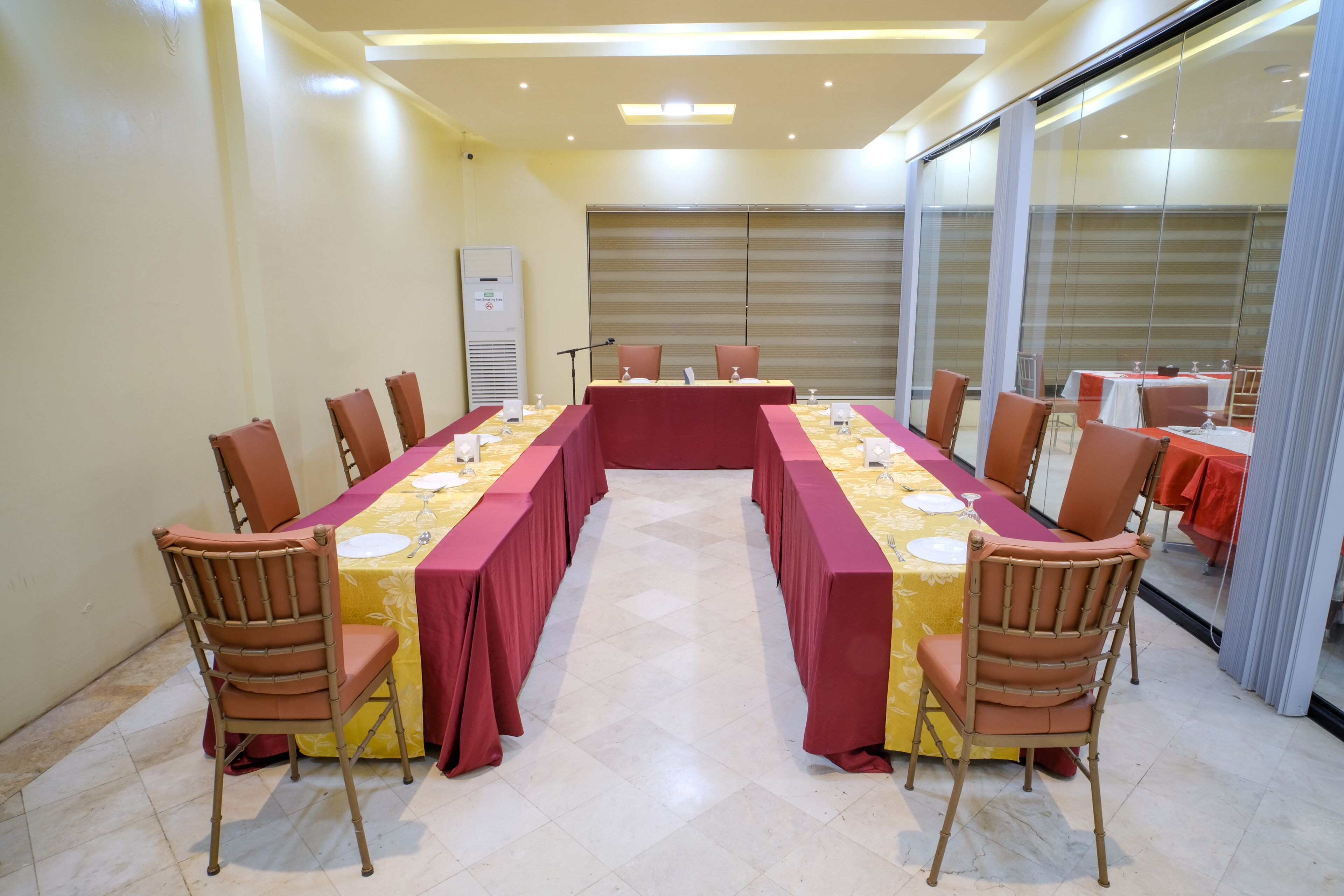 Un salón de conferencias con una mesa grande, sillas y un ventanal.
