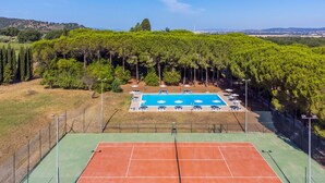 A tennis court with a pool and lounge chairs, surrounded by trees. - Nice apartment for 6 people with A/C, pool, WIFI, TV and terrace (Scarlino)