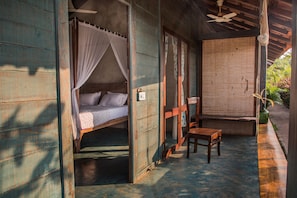 A room with a bed, a table, and a chair. - Artist Cottages (Morjim)