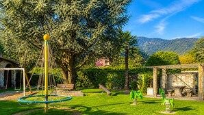 Une aire de jeux avec des balançoires, une structure d’escalade et un toboggan.
