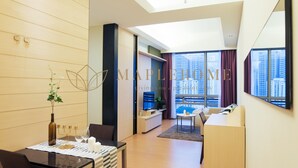 A modern living room with a dining area, a sofa, and a TV. - Swiss Garden Residence Kuala Lumpur (Kuala Lumpur)