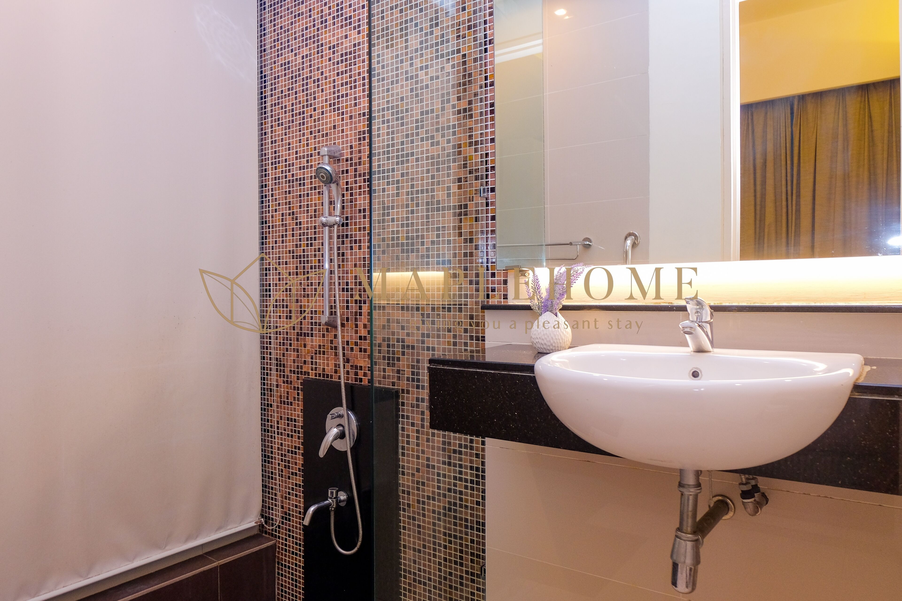 Une salle de bain avec une douche à parois de verre, un lavabo blanc et un miroir au-dessus.