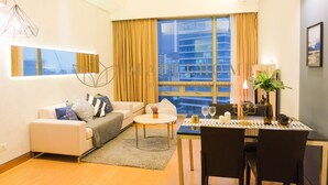 A modern living room with a sofa, coffee table, and dining area. - Swiss Garden Residence Kuala Lumpur (Kuala Lumpur)