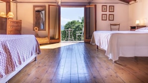 A bedroom with two beds, wooden flooring, a balcony, and a wooden ceiling. - Apartment in villa with private pool, WIFI, hot tub, A/C, TV, patio, pets allowed, panoramic view (Castiglione Del Lago)