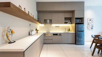 A modern kitchen with a built-in microwave, a refrigerator, and a sink.