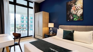 A hotel room with a bed, a desk, a chair, a wardrobe, a nightstand, a lamp, and a painting on the wall. - Geo38 Premier Suites Genting Highlands (Genting Highlands)