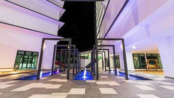 A modern outdoor area with a geometric pool design, a staircase, and a swing set.