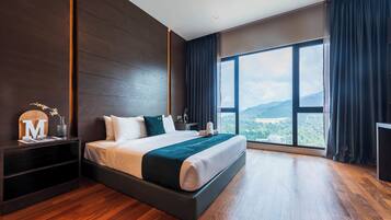 A modern hotel room with a large bed, a nightstand, a desk, and a view of the outdoors.