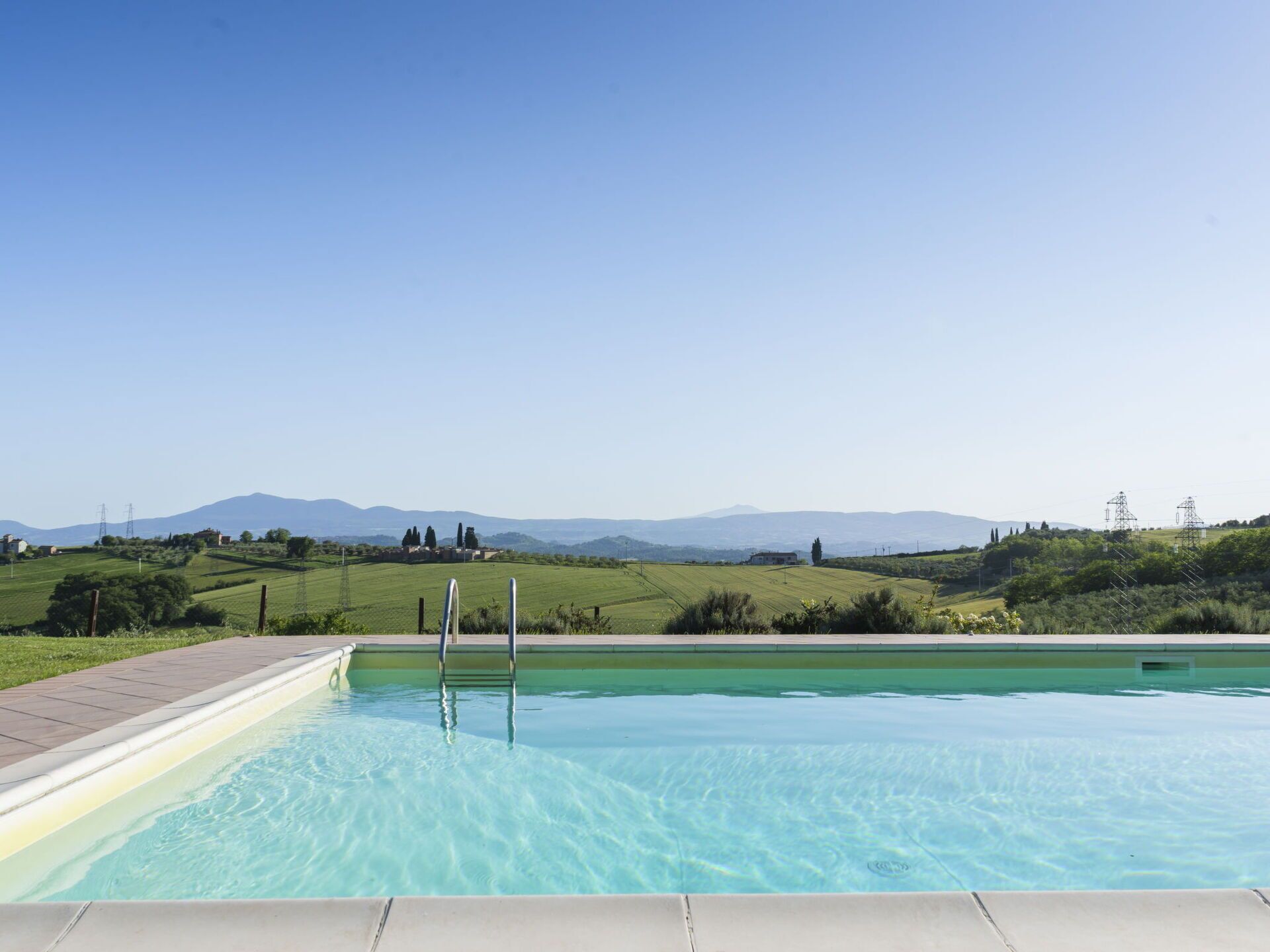 Una piscina con vistas despejadas del paisaje circundante, incluyendo colinas y montañas a lo lejos.