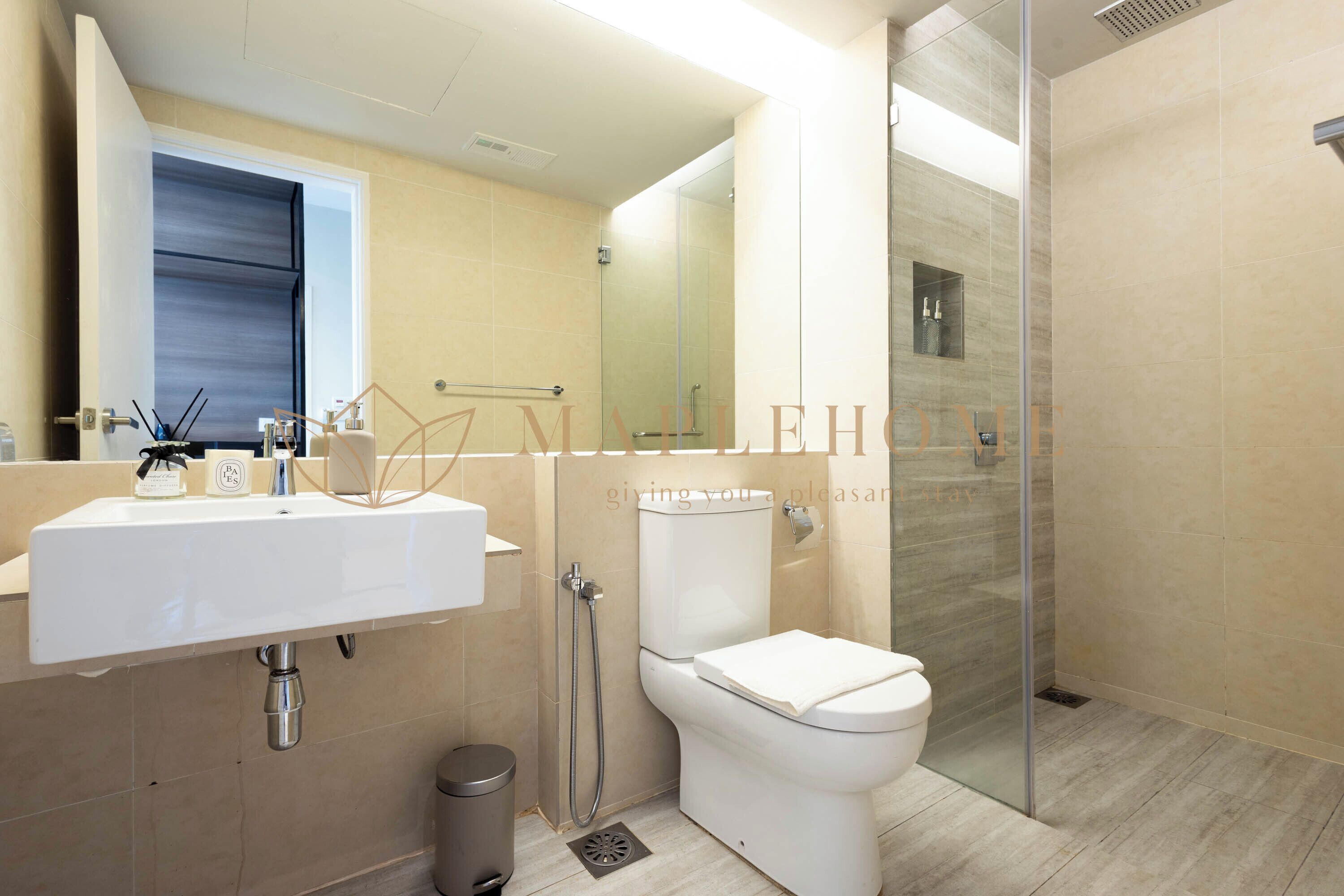 A modern bathroom with a sink, toilet, and glass-enclosed shower.