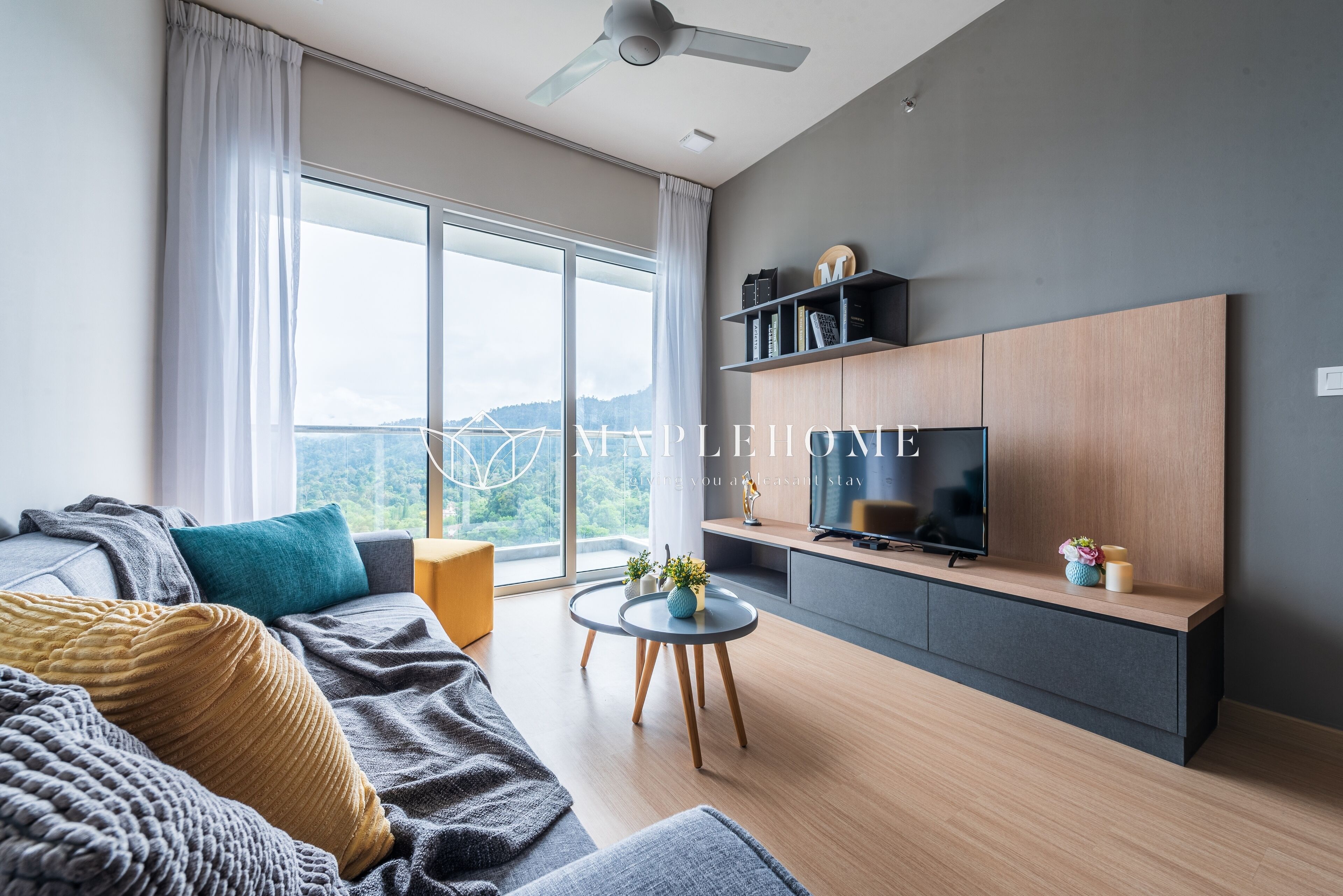 Un salon moderne avec un canapé, une table basse et un téléviseur posé sur un meuble en bois.