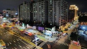 A high-rise residential building with multiple floors, surrounded by a busy urban street at night. - Modern Inn (Taichung)