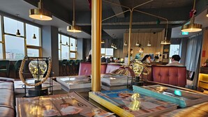 A modern interior with leather seating, pendant lighting, and a view of the city through large windows. - Modern Inn (Taichung)