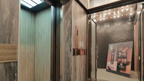 An elevator interior with wooden paneling and a metal mesh door. - Modern Inn (Taichung)
