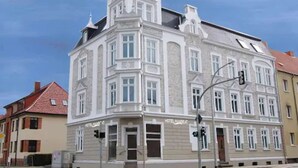 Un bâtiment historique doté d’une tour d’angle remarquable et d’une enseigne indiquant qu’il s’agit d’un hôtel.