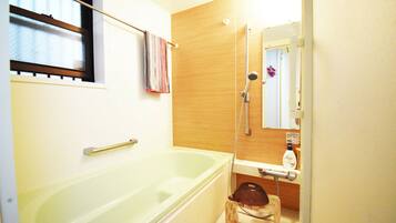 Shower, deep soaking tub, slippers, towels