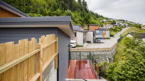 A residential area with modern houses, a wooden fence, and a stone retaining wall. - MyHolidays - The Four Seasons Queenstown (4 brms + 4.5 bathrooms) (Queenstown)
