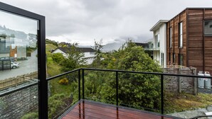 A modern building with a wooden exterior and a balcony with a metal railing. - MyHolidays - The Four Seasons Queenstown (4 brms + 4.5 bathrooms) (Queenstown)