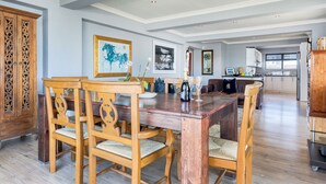 Ein geräumiger Essbereich mit einem Holztisch und -stühlen, im Hintergrund eine Küche und ein dekorativer Schrank.