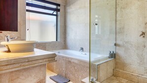 Ein Badezimmer mit Badewanne, einer Duschkabine und einem Waschbecken mit Spiegel.