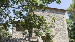A stone building with a tiled roof and a staircase leading to a door. - Lovely apartment in villa for 6 people with WIFI, pool, TV, patio and pets allowed (Bagnoregio)