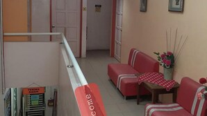 A hotel lobby with a reception desk, red seating area, and decorative ceiling lights. - Hotel Sri Bahau (Bahau)