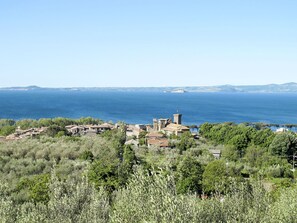 A coastal village with traditional architecture, including a prominent tower, surrounded by lush greenery and a view of the sea. - Nice apartment in villa for 4 guests with pool, WIFI and patio (Castiglione In Teverina)