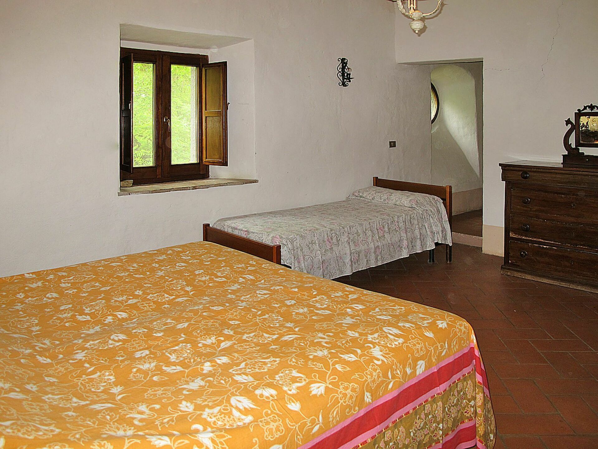 Un dormitorio con dos camas, un tocador, una ventana y una puerta.