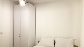 A bedroom with a bed, white curtains, and a wardrobe. - next to Soroka and BGU (Beer sheva)