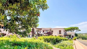 Un hotel con varias edificaciones, abundante vegetación y cielo despejado.
