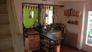 A compact kitchen with a wooden counter, hanging pendant lights, and a radiator. - 110m2 house + pool, No neighbors, in the countryside between Uzès and Cévennes (Occitanie)