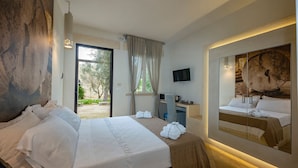 A hotel room with a bed, a desk, a television, and a large mirror reflecting the bed. - Tenuta Sidore (Cursi)