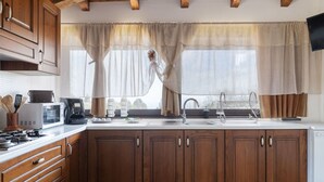 Une cuisine avec des meubles en bois, un four à micro-ondes, une cuisinière et un évier.