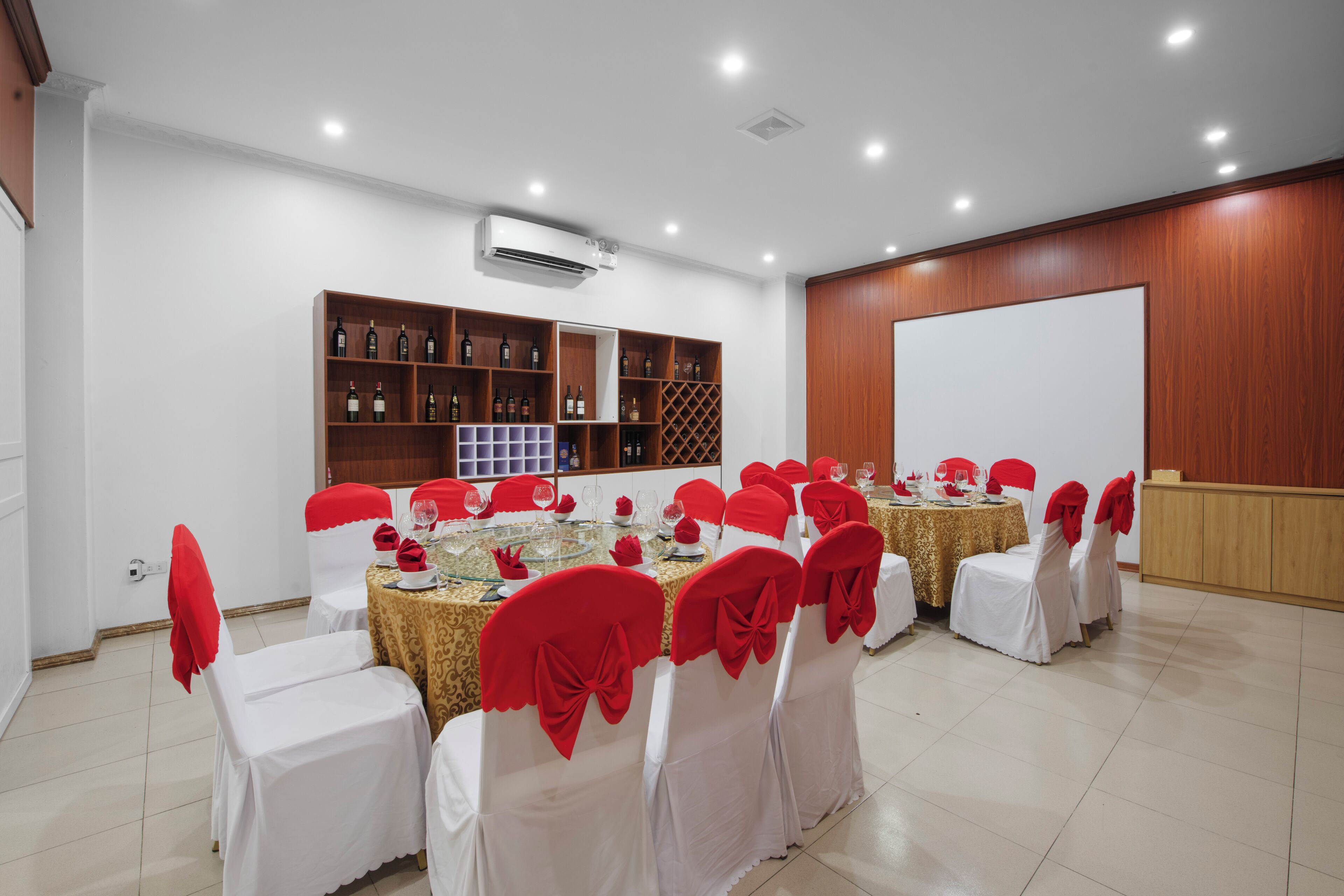 A conference room with multiple tables and chairs, air conditioning, and a whiteboard.